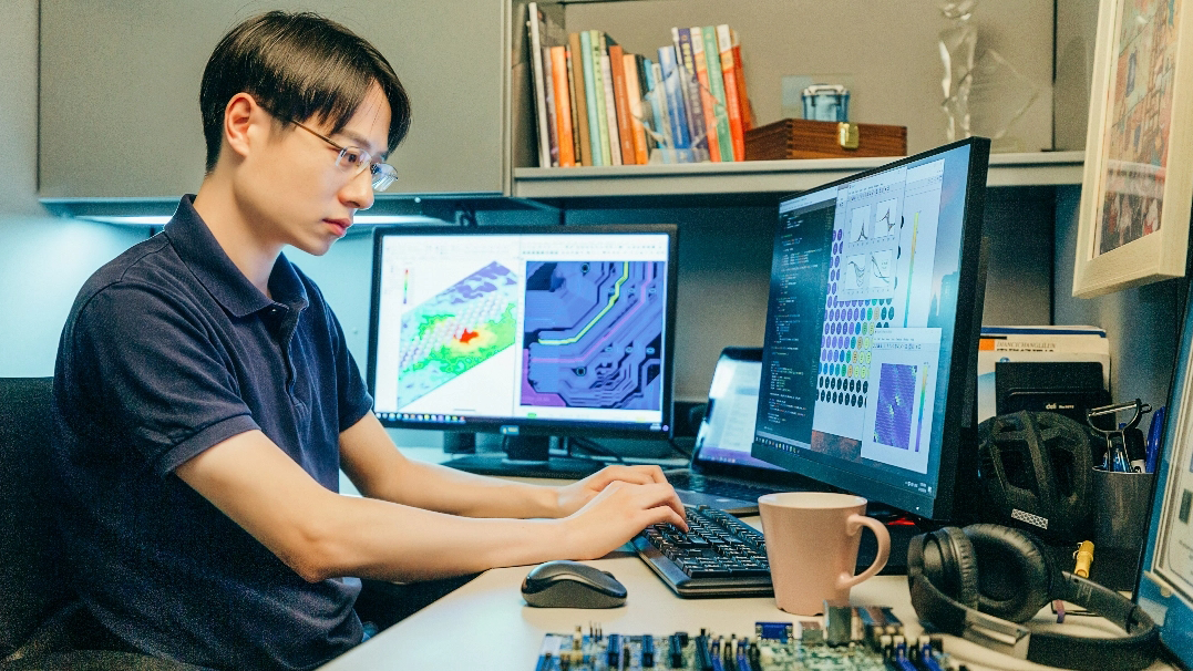 A coder surrounded by screens